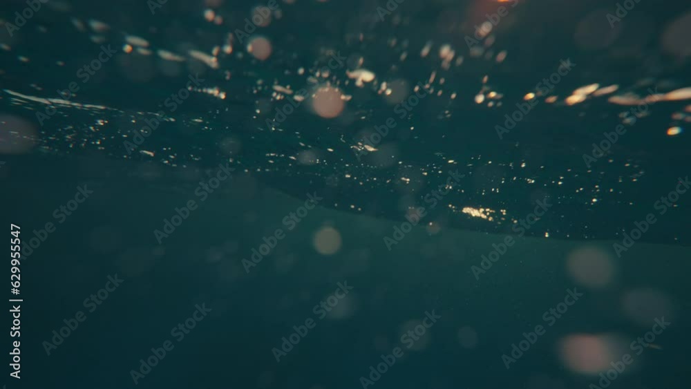 SLOW MOTION, UNDERWATER: Massive turquoise barrel wave breaks over the camera on a sunny summer evening in the scenic Caribbean. Cinematic view of a crystal clear breaking ocean wave at golden sunset.