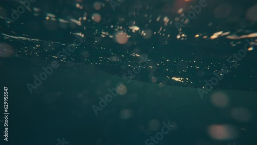 SLOW MOTION, UNDERWATER: Massive turquoise barrel wave breaks over the camera on a sunny summer evening in the scenic Caribbean. Cinematic view of a crystal clear breaking ocean wave at golden sunset.