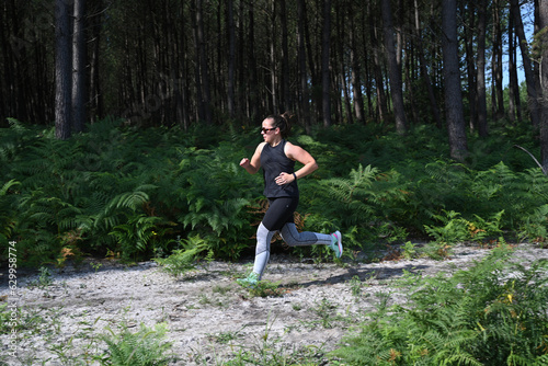 young woman doing sports in front of a pine forest