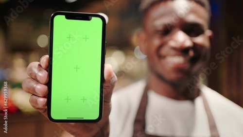 Blurred African American man holds smartphone with chromakey