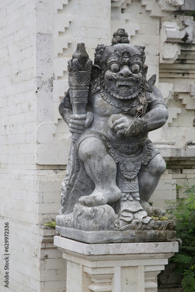 Balinese white sandstone statue in front of temple