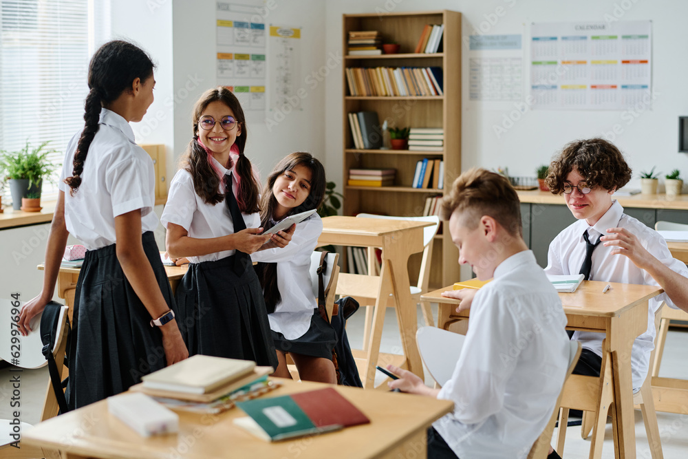 Fototapeta premium Group of school children talking to each other during break at school