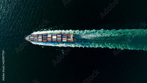 cargo container ship sailing full speed in sea to import export goods and distributing products to dealer and consumers worldwide, by container ship Transport business delivery service, aerial view