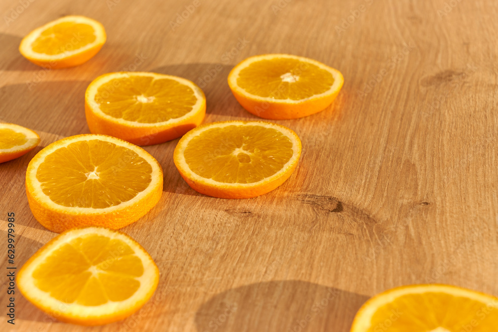 Slices of fresh organic oranges on a wooden kitchen table. Slices of fresh organic oranges on a wooden kitchen table.