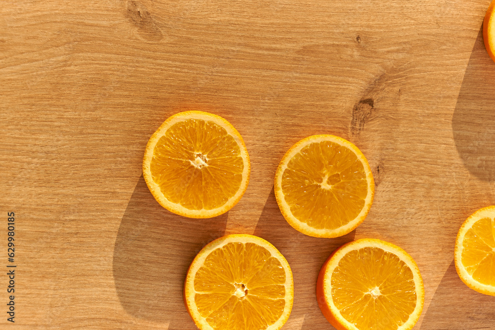Slices of fresh organic oranges on a wooden kitchen table.
