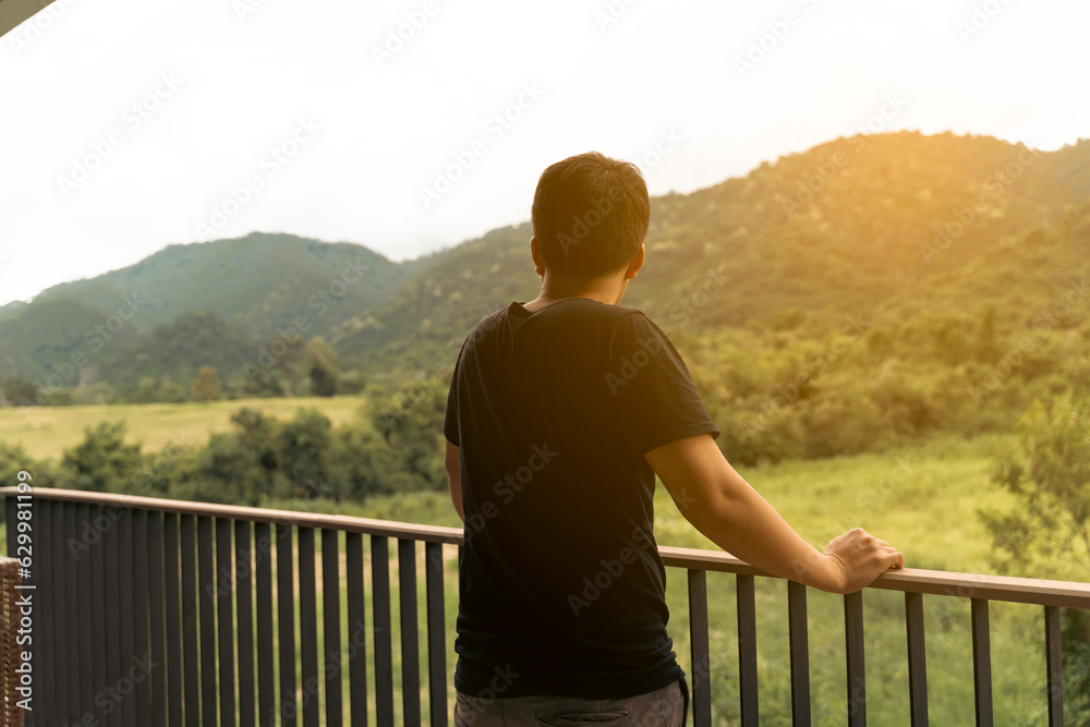 Middle-aged men Stand alone on the balcony and look outside with sunlight, Sadness women,  Depression concept, health problems.