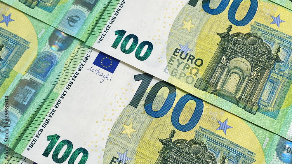 100 euros. Financial business background concept. Close-up of one hundred euro bills. Green background of money. European currency. Cash banknotes. 100 euros. Financial business background concept. Close-up of one hundred euro bills. Green background of money. European currency. Cash banknotes.