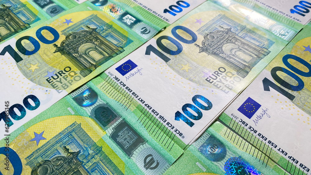 European currency. Stacks of 100 euro bills. Green background of money. Cash banknotes. One hundred euros. The single currency of the European Union. European currency. Stacks of 100 euro bills. Green background of money. Cash banknotes. One hundred euros. The single currency of the European Union.