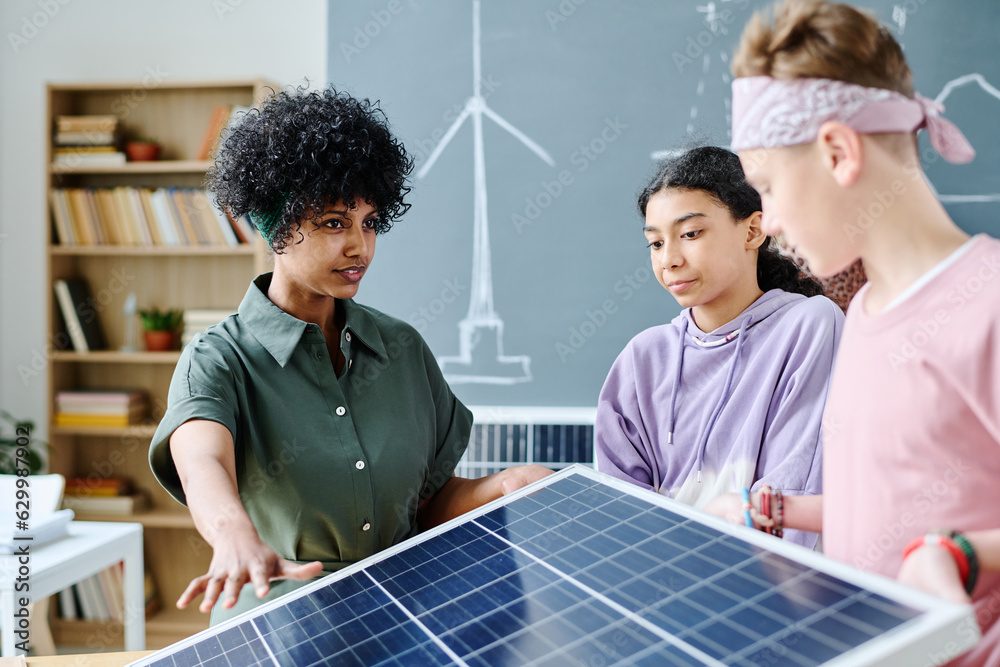 Fototapeta premium Teacher showing solar panel to students during lesson in classroom