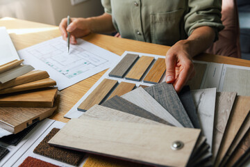 interior designer working on new house design project in office. choosing flooring and furniture materials and colors from samples
