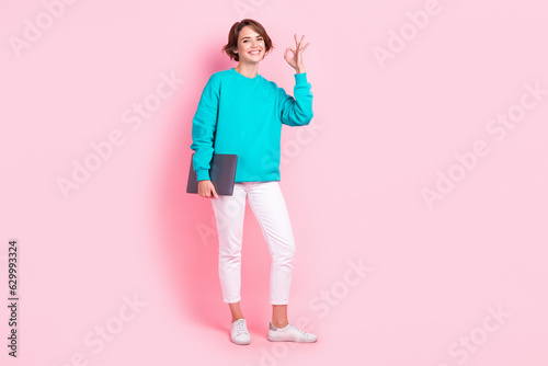 Full size photo of pretty young girl digital nomad show okey sign employee wear trendy blue outfit isolated on pink color background