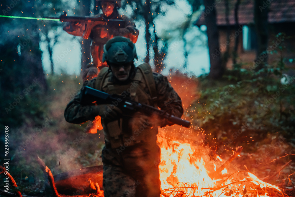 Soldier in Action at Night in the Forest Area. Night Time Military Mission jumping over fire Soldier in Action at Night in the Forest Area. Night Time Military Mission jumping over fire