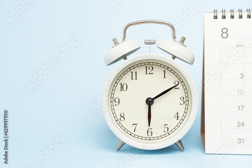 close up of calendar and alarm clock on the blue table background, planning for business meeting or travel planning concept