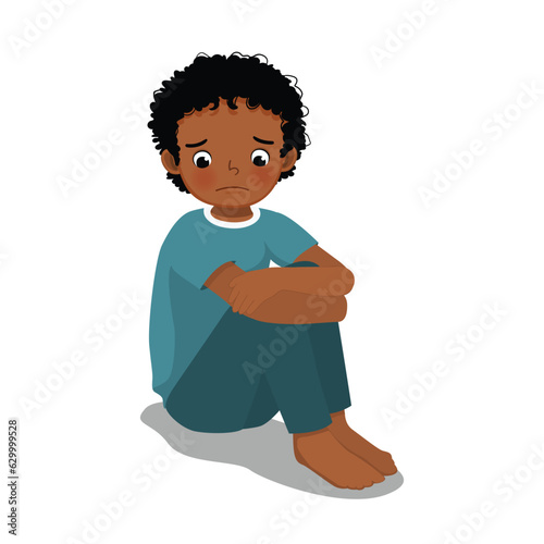 Sad little African boy sitting with hands holding his knee