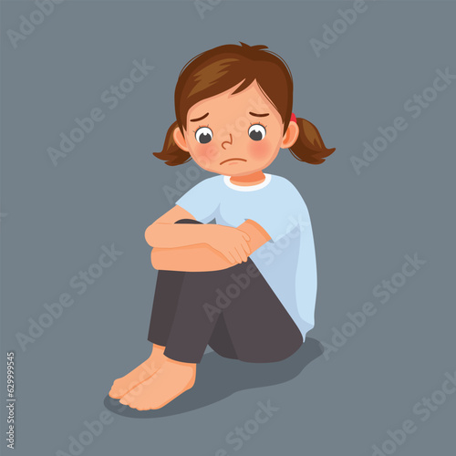 Sad little girl sitting with hands holding her knee