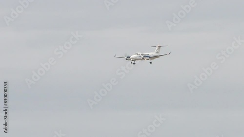Generic Unmarked Twin-Turbo Propeller Private Plane Flying in a Cloudy Sky with Landing Gear Extended