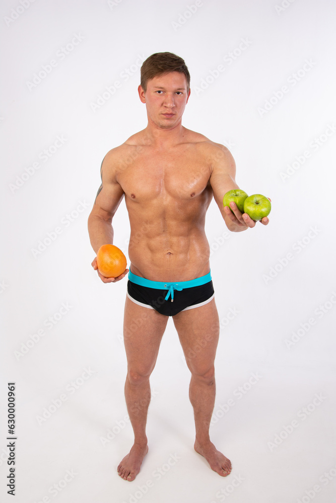 Sports, healthy eating and a healthy lifestyle. Young attractive man on a diet. Athletic handsome guy posing with sports nutrition in the studio.