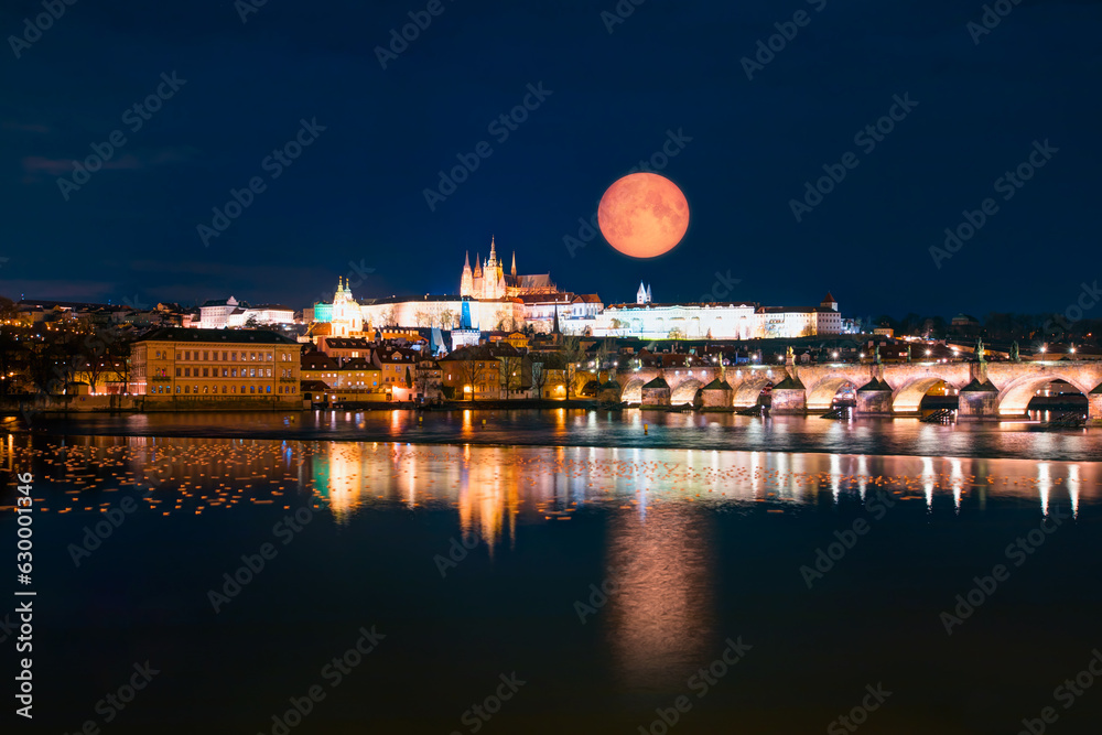 Prague Castle and Charles Bridge, Prague, Czech Republic, Vltava river in foreground with full moon 
