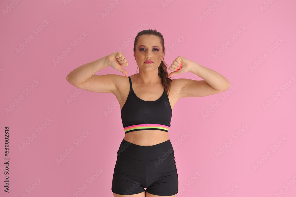 mulher com roupa de treino apontando para anúncio ou promoção, expressão negativa mulher com roupa de treino apontando para anúncio ou promoção, expressão negativa