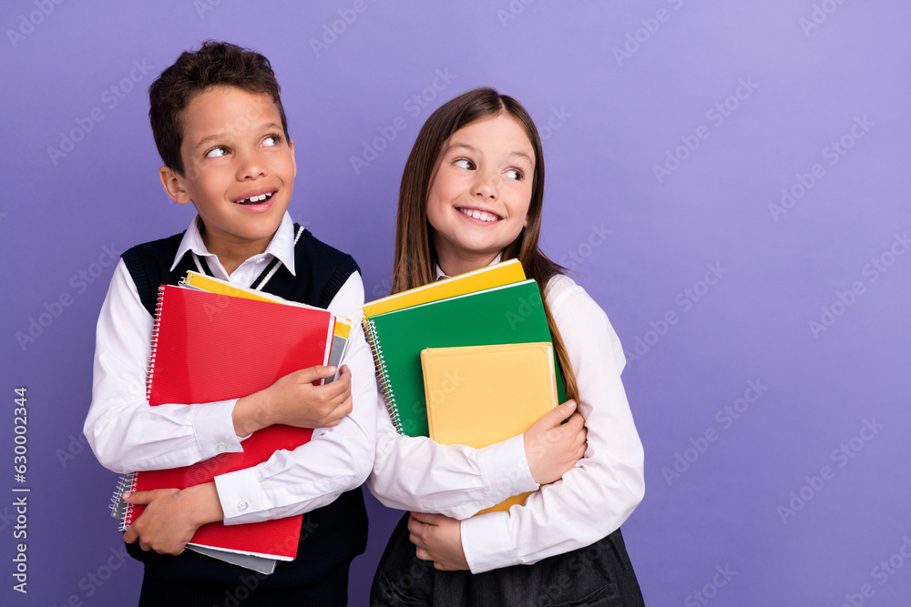 Photo of two schoolkids look empty space advertise season school discounts on textbooks encyclopedia isolated bright color background Photo of two schoolkids look empty space advertise season school discounts on textbooks encyclopedia isolated bright color background