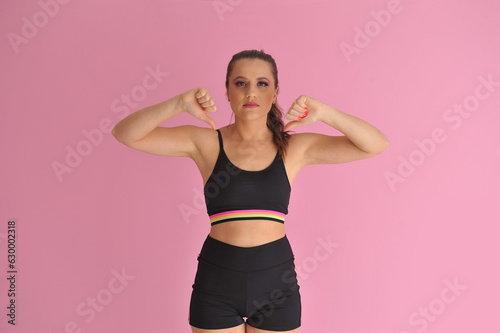 mulher com roupa de treino apontando para anúncio ou promoção, expressão negativa  © Alexandre