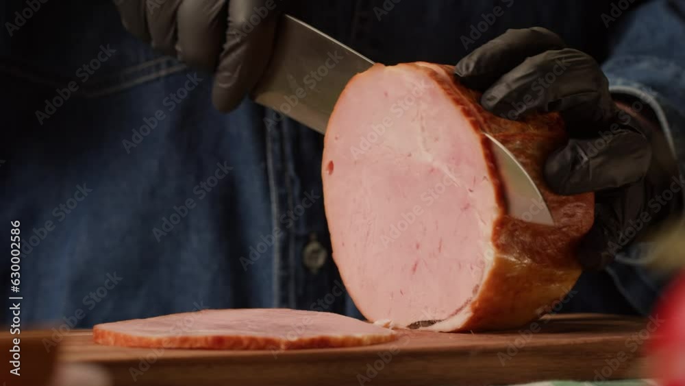 Woman slices ham bacon meat thick pieces on a wooden board, beef or pork jamon. Chef cooking breakfast, smoked bacon in cafe. 