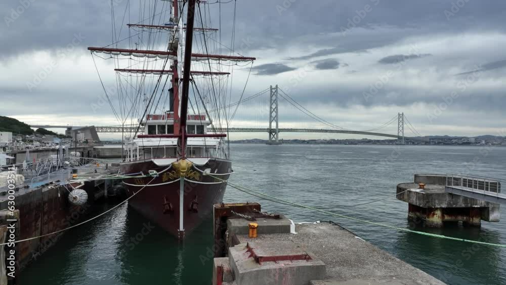 Rising up over historic sailing ship to modern suspension bridge on cloudy day Rising up over historic sailing ship to modern suspension bridge on cloudy day