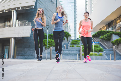 three young sportive women running outdoors training
