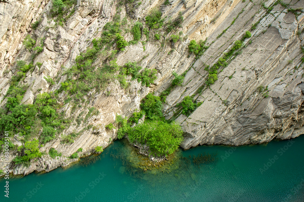 Island with a tree at the bottom of a canyon with emerald water (Dagestan) Island with a tree at the bottom of a canyon with emerald water (Dagestan)