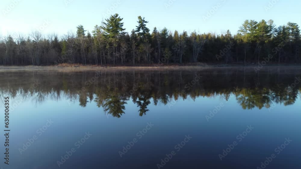 Aerial video of a calm river reflecting trees in the shore on a foggy day Aerial video of a calm river reflecting trees in the shore on a foggy day