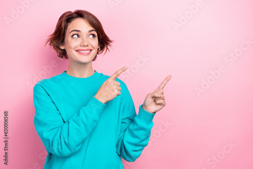 Photo of pretty curious woman indicating fingers empty space interesting poster wear oversize pullover isolated pink color background