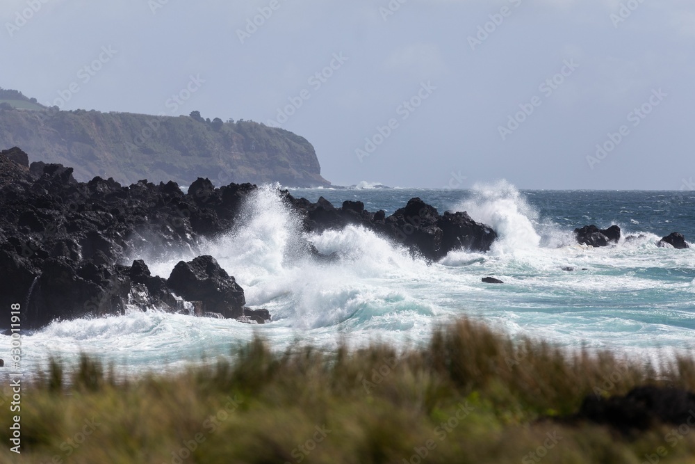 Scenic view of sea waves crashing against rocky cliffs in Azores islands, Portugal