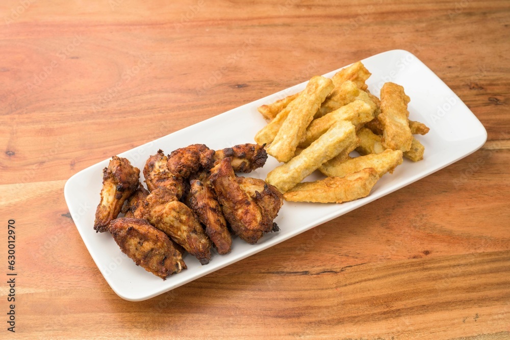 a plate filled with temperateon chicken and fries on top