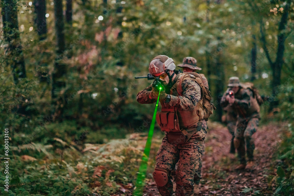 A group of modern warfare soldiers is fighting a war in dangerous remote forest areas. A group of soldiers is fighting on the enemy line with modern weapons. The concept of warfare and military