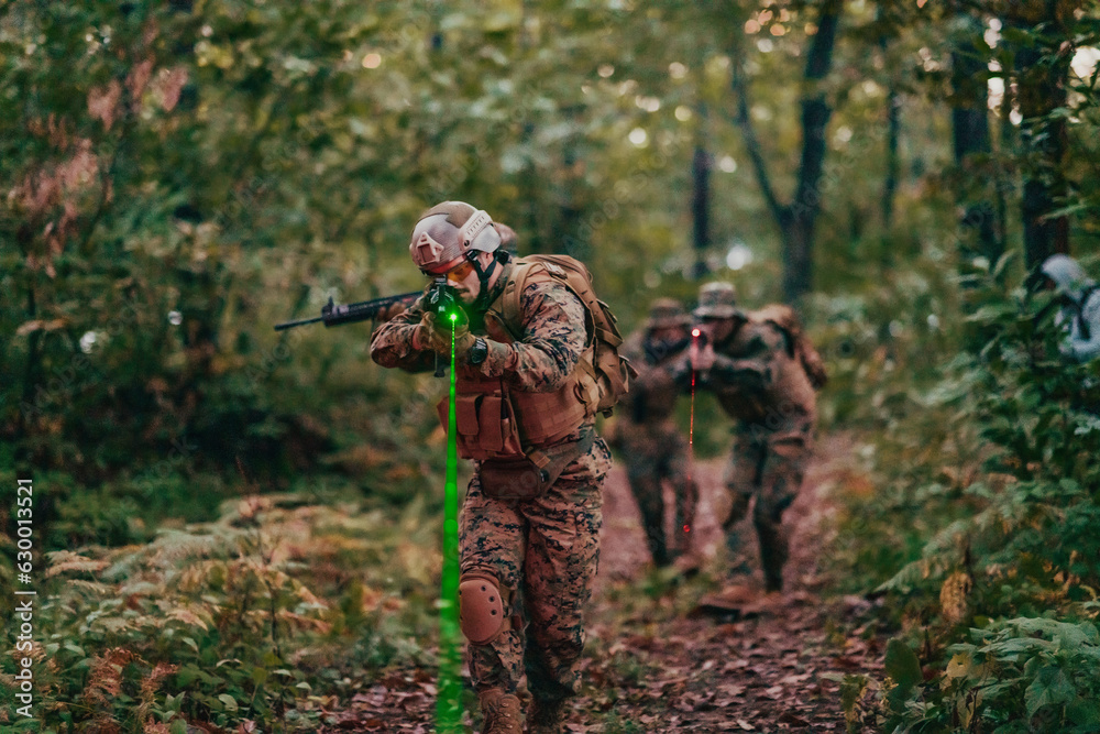 Naklejka premium A group of modern warfare soldiers is fighting a war in dangerous remote forest areas. A group of soldiers is fighting on the enemy line with modern weapons. The concept of warfare and military