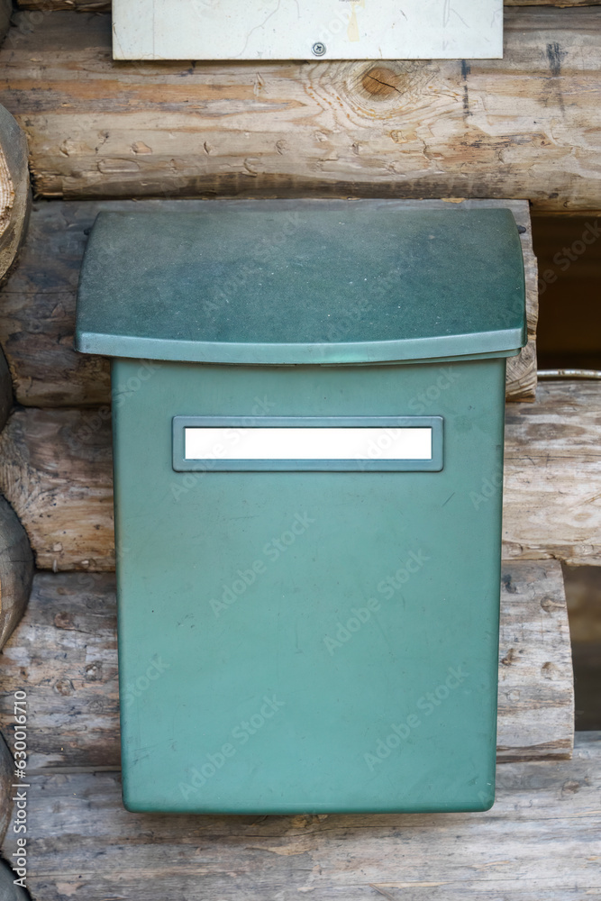 Mailbox with empty white label outside the wooden lean-to shelter