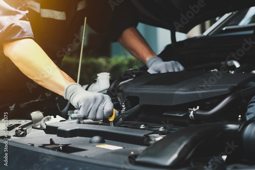 car mechanic image and on-site car repair services Image of a mechanic holding a wrench repairing a car