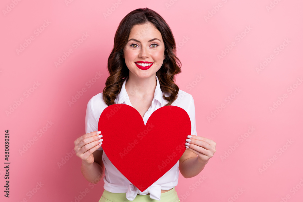 Photo of cheerful sweet lady wear white blouse rising big read heart smiling isolated pink color background Photo of cheerful sweet lady wear white blouse rising big read heart smiling isolated pink color background
