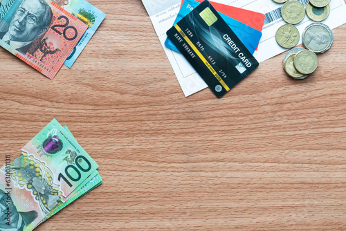 Top table view or flat lay of Australian 100 dollars bills, 20 dollars bills, coins and credit card with copy space in below frame