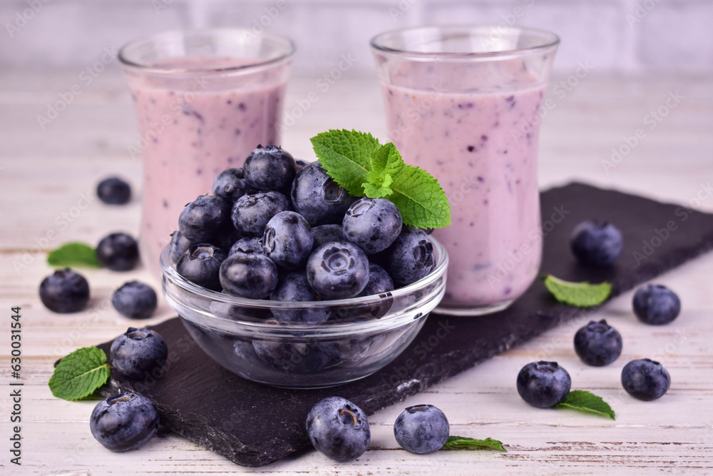 Blueberries and blueberry smoothie on a white background.
