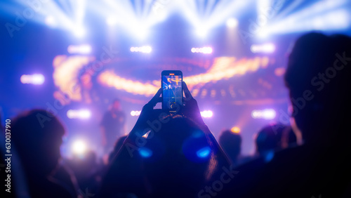 People holding smart phone and recording and photographing in concert , silhouette of hands with mobile , event background concept