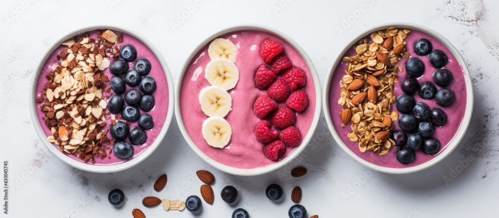 Pink and black currant berries are featured in a banana smoothie bowl on a light gray concrete background. Pink and black currant berries are featured in a banana smoothie bowl on a light gray concrete background.