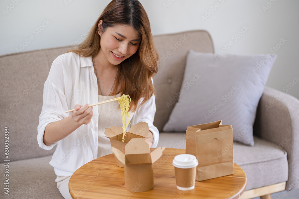 Asian woman with takeaway food and drinks at home. consumption eating home delivery food. enjoying delicious takeaway delivery tasty meal