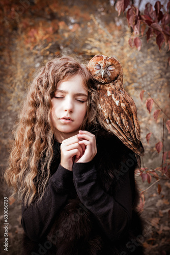 a girl in an autumn forest with an owl