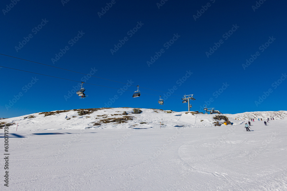 Breathtaking view of a snow-capped mountain in the Dolomites, with a chairlift. The majestic peaks loom in the distance, blanketed in snow. ascends towards the summit, providing inspiring view Breathtaking view of a snow-capped mountain in the Dolomites, with a chairlift. The majestic peaks loom in the distance, blanketed in snow. ascends towards the summit, providing inspiring view
