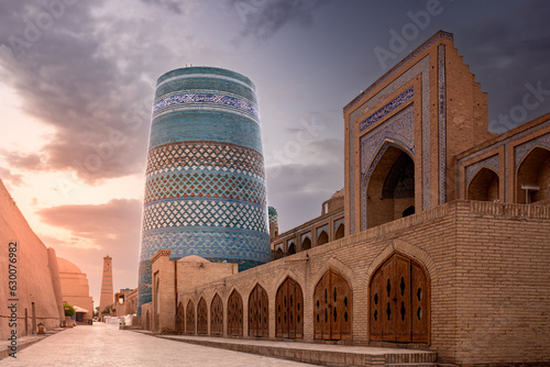 Old city view with iconic Kalta Minor minaret and ancient madrasah at sunset, Khiva, Uzbekistan
