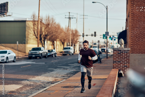 Young man jogging in a town on a street