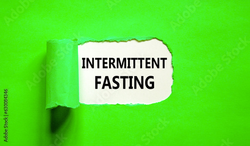 Intermittent fasting symbol. Concept words Intermittent fasting on beautiful white paper. Beautiful green background. Healthy lifestyle intermittent fasting concept. Copy space.