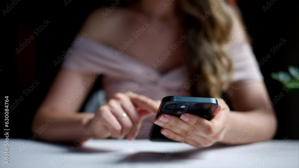 Woman working on blue mobile phone at a restaurant Woman working on blue mobile phone at a restaurant