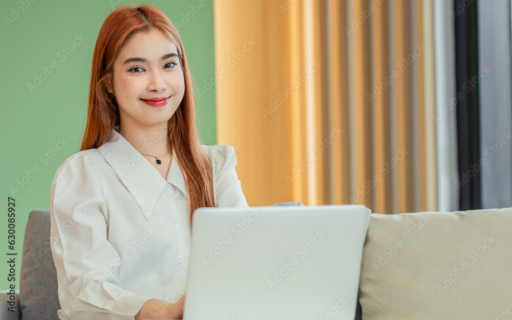 Beautiful Asian business woman sitting in modern office, using laptop for planning tasks or works, smiling, looking at camera. Entrepreneur, Business Owner Concept. Beautiful Asian business woman sitting in modern office, using laptop for planning tasks or works, smiling, looking at camera. Entrepreneur, Business Owner Concept.